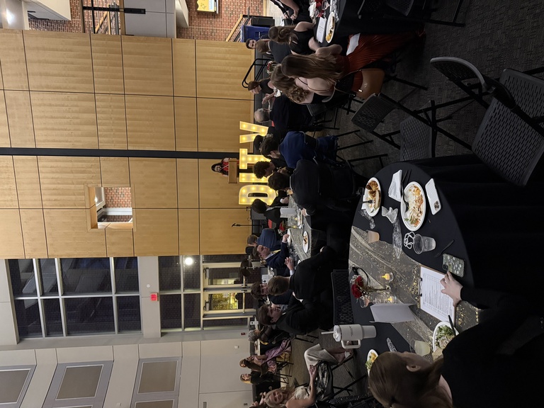 Students sitting at tables during the presentation of the 20th anniversary for DITV