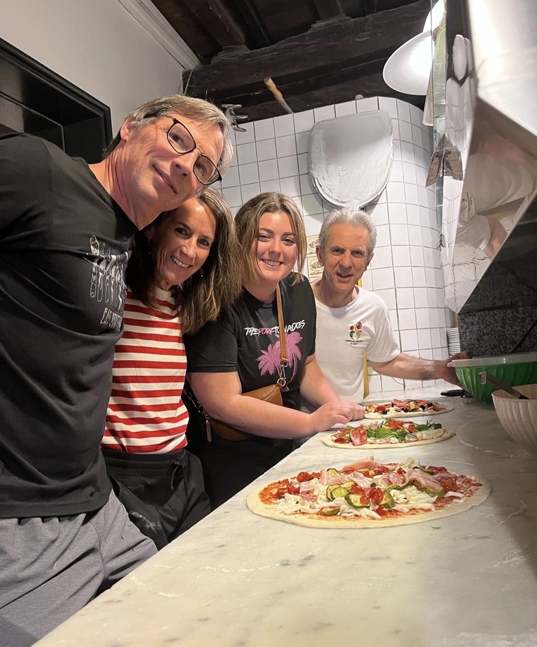 Tracy/Mike/Claire posing for a photo with pizza during CIMBA